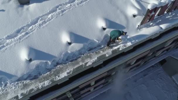 Man Ploegt Sneeuw Rand Van Het Dak Van Het Gebouw — Stockvideo