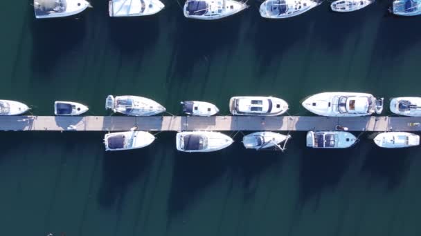 一艘自上而下的无人侦察机拍摄的浮桥 向右飞去 许多游艇和汽艇停泊在上面 人们可以看到他们正在浮桥上享受他们的小船 — 图库视频影像