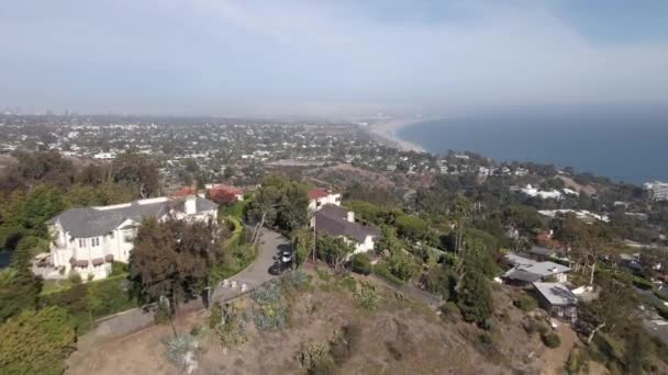 サンタモニカとビーチを見下ろす邸宅の上空を飛ぶ — ストック動画