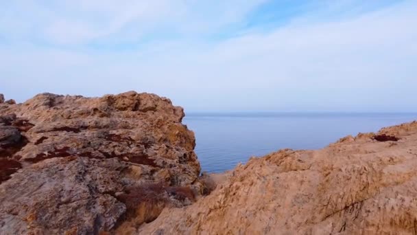 从红色的岩石上打了一枪 放大镜头在岩石之间移动到开阔的大海 — 图库视频影像