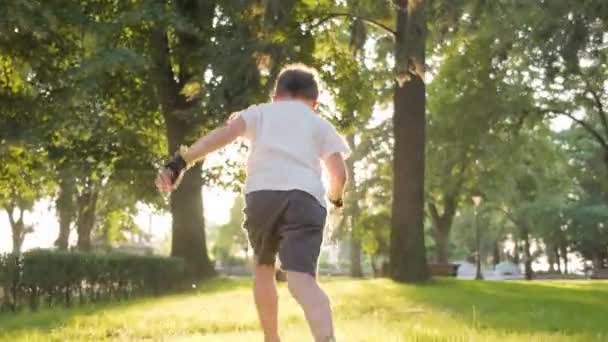 Bambino Camicia Bianca Che Corre Nel Parco Verso Sole Inseguimento — Video Stock