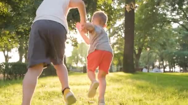 日光の手の中に2人の子供が走り 撮影を追跡 — ストック動画