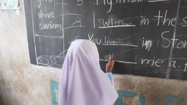 伊斯兰英语教育 女孩穿着Hijab Burqa写在黑板4K上 — 图库视频影像