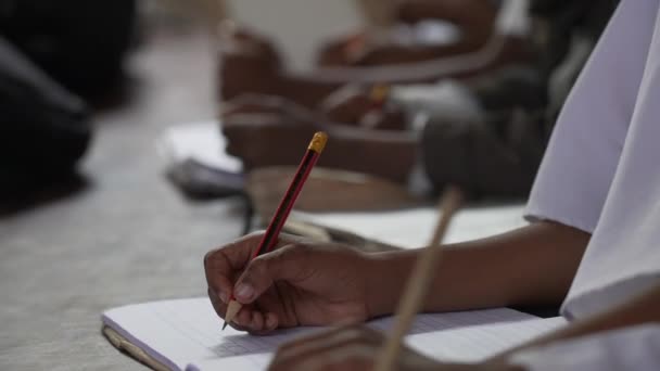 在学校的阿拉伯裔穆斯林孩子在她的笔记本上写字 伊斯兰国家的教育 用铅笔拍手的特写 3个世界贫穷国家的教育 非洲4K — 图库视频影像