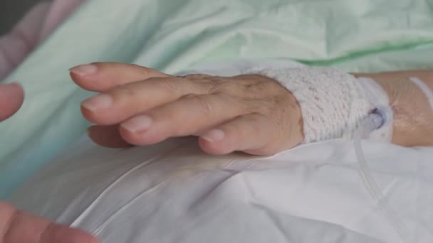 Man Holds Hand Elderly Patient Attached Intravenous Line Hospital Close — Αρχείο Βίντεο