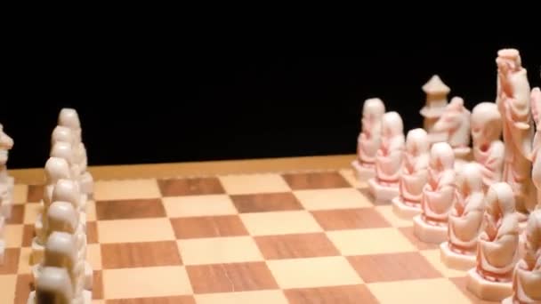 象牙のチェスボードの回転 黒の背景でクローズアップ — ストック動画