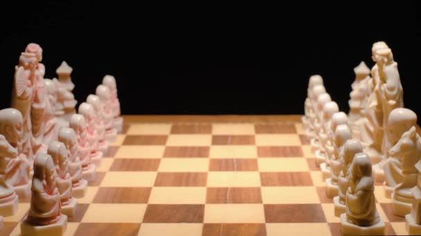 チェス盤のコンセプト 形成中の部分 人の手は一つの駒を前に動かす 黒の背景 — ストック動画