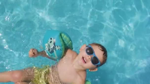 Chico Guay Mirando Cámara Con Gafas Sol Flotadores Piscina Agua — Vídeos de Stock