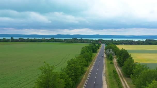 Samochód Jedzie Nad Jezioro Autostradzie Pięknym Tle Deszczowym Nagrania Drone — Wideo stockowe