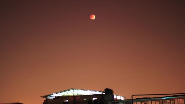 前景の建物と背景の赤い空と血の月の上昇と遷移時間の経過 — ストック動画