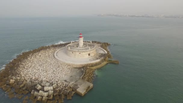 水平線にリスボンの景色を望む海の真ん中に素晴らしい灯台 ポルトガルでのドローンによる空中撮影 — ストック動画