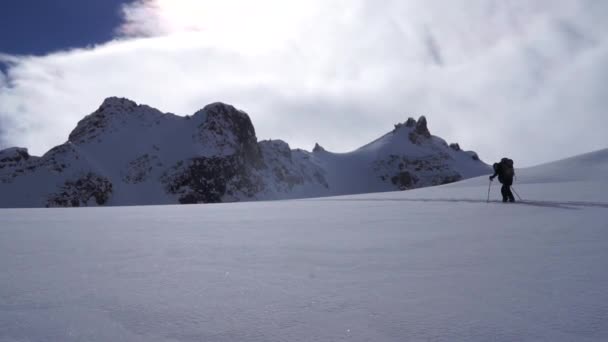 Lone Backcountry Skier Ascending Skintrack Jagged Ridgeline Background — Stock Video