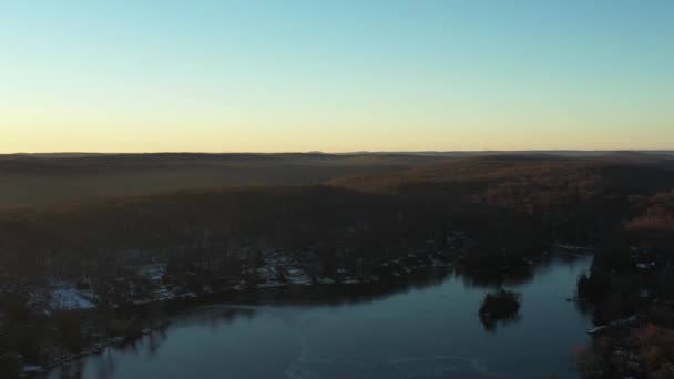Dron Przelatuje Nad Zimowym Jeziorem Zaśnieżone Wzgórza Pokryte Lasem Wschodzie — Wideo stockowe