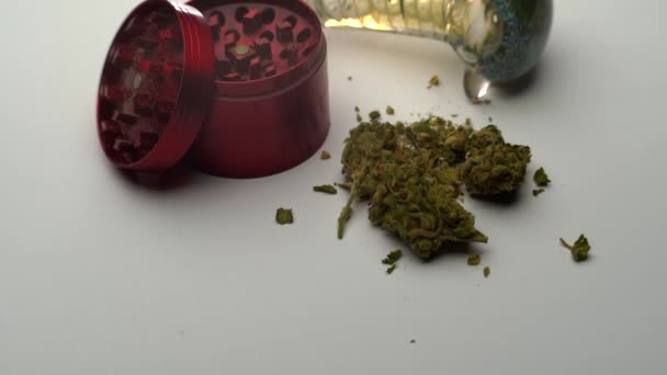 Closeup Ground Marijuana Lying White Table Next Red Grinder Glass — Stockvideo