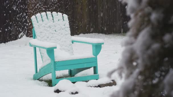 Still Shot Snow Falling Snowy Backyard Teal Lawn Chair Front — стоковое видео