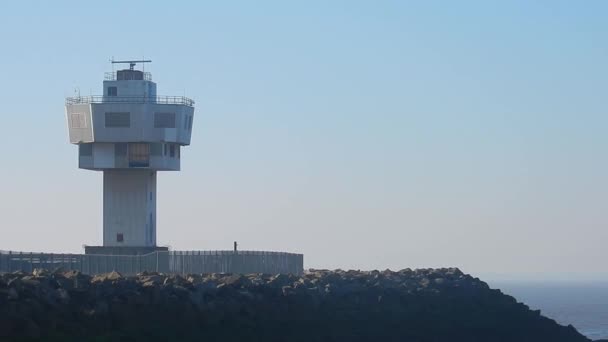 雷达塔旋转天线顶部岩石海岸线 背景中的海洋观点 — 图库视频影像
