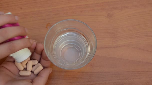 Frau Nimmt Rosa Pillen Und Stellt Glas Wasser Wieder Auf — Stockvideo