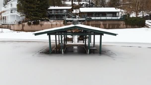 Flying Backwards Aerial Shot Covered Dock Frozen Lake — Αρχείο Βίντεο