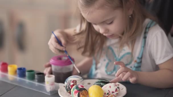 Дитяча Дівчинка Сидить Столом Малює Яйця Лежать Тарілці Різними Кольорами — стокове відео