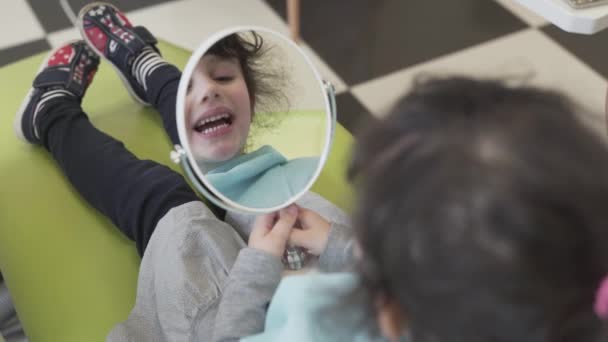 Baby Girl Sits Chair Dentist Office Holds Big Oval Mirror — Vídeos de Stock