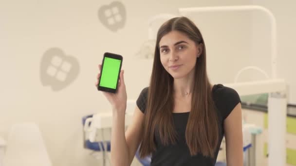 Sevimli Genç Bir Kadın Dişçi Kliniğinde Oturuyor Elinde Bir Telefon — Stok video