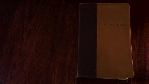 从上往下拍摄一本皮制装订的圣经 在一张木制桌子上被打开 翻看彼得一世的书 — 图库视频影像