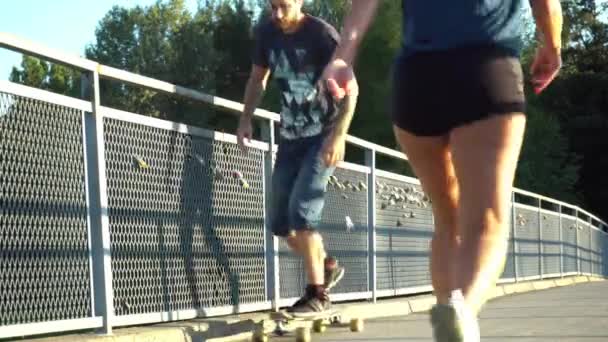 Young Male Man Skating Longboard Bridge While Young Lady Walking — Vídeo de Stock