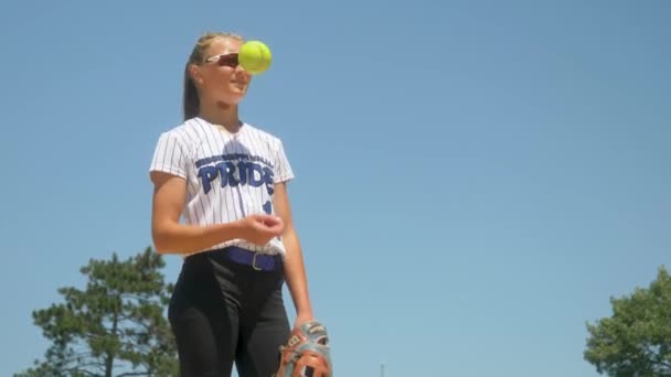 Pemain Softball Wanita Berseragam Putih Tosses Bola Kuning Naik Dan — Stok Video