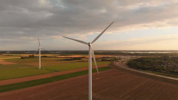 荷兰西南部日落期间的风力涡轮机 有太阳光的动态航拍 在主题周围盘旋向上 缓慢倾斜 — 图库视频影像