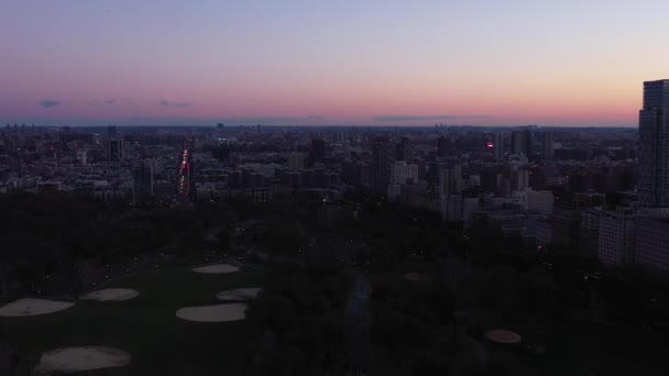 ニューヨーク市中央公園の北端を飛行する遅い無人機 夜明けの日の出の青の時間に見えるボールフィールド ハーレムとアッパーイーストサイド 4Kでは — ストック動画