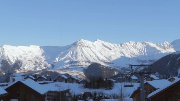 手前の村のあるアルプスのスキー場で山の上の夕日の時間経過 — ストック動画