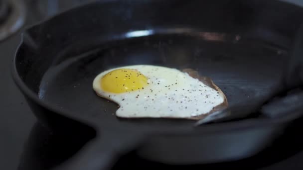 Spachtel Spiegelt Ein Gewürztes Spiegelei Einer Gusseisernen Pfanne — Stockvideo