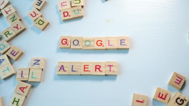 Någon Stavar Google Alerts Med Träbokstäver Ett Bord Med Andra — Stockvideo
