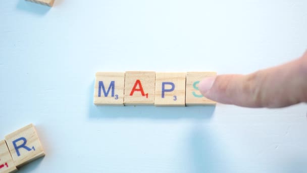 在蓝色的白色背景上用木制字母拼写地图 平面飞机 — 图库视频影像