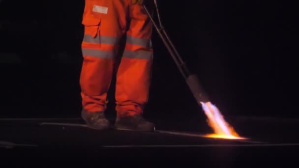 道路工人在夜间重新粉刷前用热喷枪焚烧主干道上的白线的慢镜头 — 图库视频影像