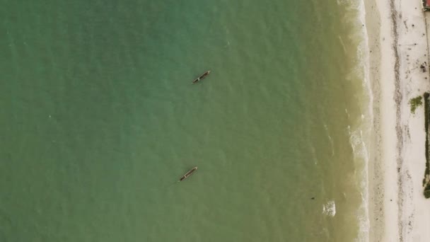 タンザニアのダルエスサラームの海岸近くに停泊する2隻の木製のカヌーボートの空中撮影 — ストック動画