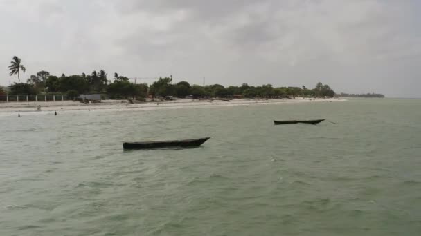 タンザニアのダルエスサラーム近くのビーチサイド近くに停泊している2隻の木製漁船の静的なショット — ストック動画