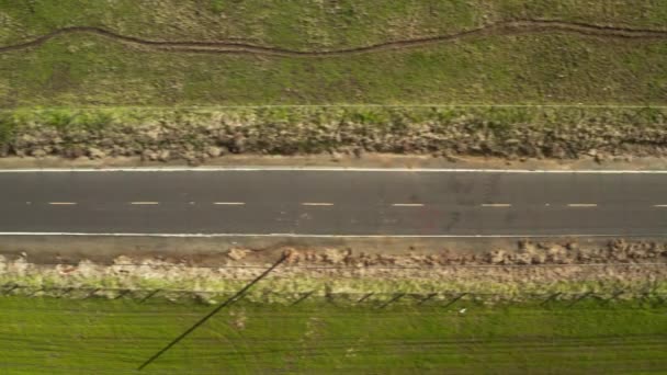 Overhead Shot Road Leading Green Rolling Hills Blue Sky White — стоковое видео