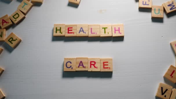 Jemand Buchstabiert Health Care Mit Holzbuchstaben Auf Weißem Hintergrund Mit — Stockvideo