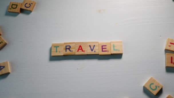 Τραπέζι Διάσπαρτα Ξύλινα Γράμματα Και Ένα Άτομο Που Συλλαβίζει Ταξίδια — Αρχείο Βίντεο