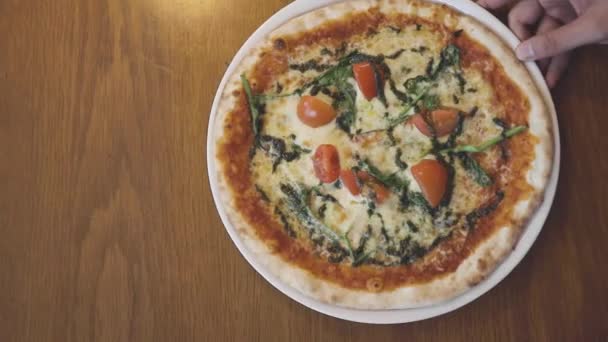 Person Schiebt Eine Frische Pizza Über Einen Hölzernen Restauranttisch Wobei — Stockvideo