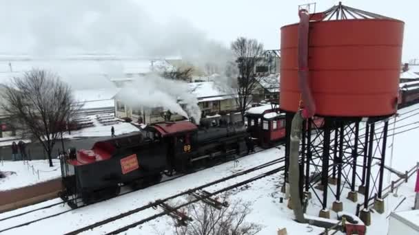 Aerial Restored Steam Powered Train Slowly Rolls Red Water Tank — стоковое видео