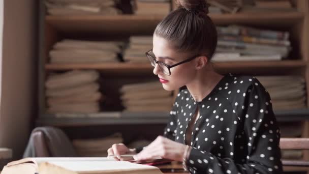 Woman Looks Book While Making Notes Library — Αρχείο Βίντεο