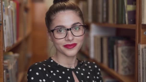 Woman Smiles Putting Glasses Library — Stock Video