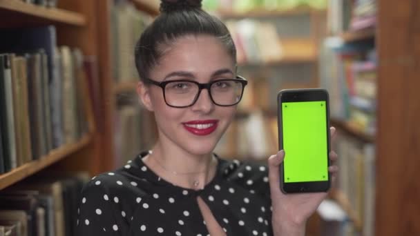 Woman Standing Book Shelves Showing Smartphone Library — Stock Video