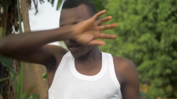 暑いアフリカの太陽の下で働いて庭を掘った後 彼は彼の眉から汗を拭くようにアフリカの男性の顔の近いショット — ストック動画