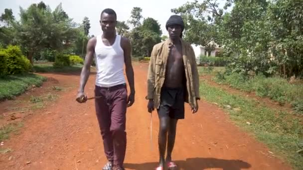 两名拿着武器在非洲农村行走的非洲匪帮正面对着慢镜头射击 — 图库视频影像