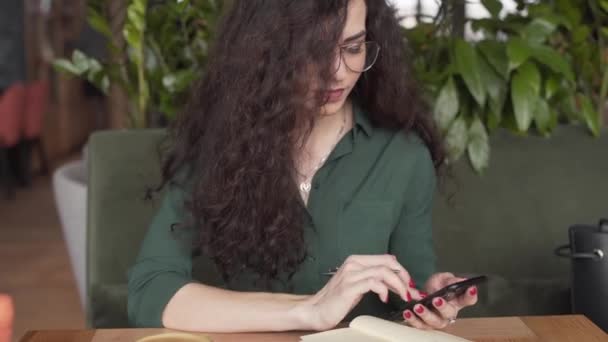 Mujer Profesional Joven Hace Investigación Teléfono Inteligente Escribe Cuaderno Mientras — Vídeo de stock