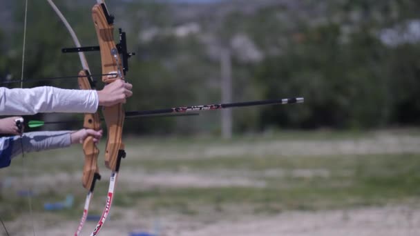 Die Arme Reichen Sich Mit Bogenbögen Die Hand Und Schießen — Stockvideo