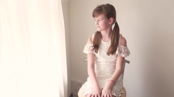 Kaukaska Dziewczyna Dziecko Siedzi Krześle Przez Okno Białej Sukience Włosy — Wideo stockowe
